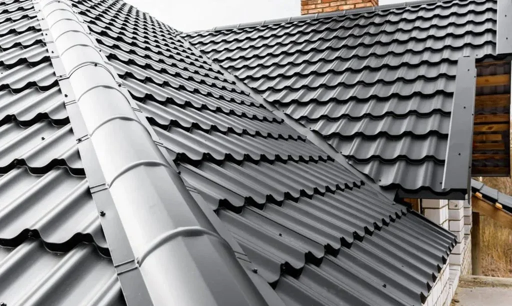 Dark grey tile and corrugated roofing after a full repaint