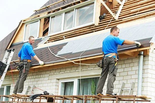 Two painters working on the fascia and roofline of a brick Hamilton home